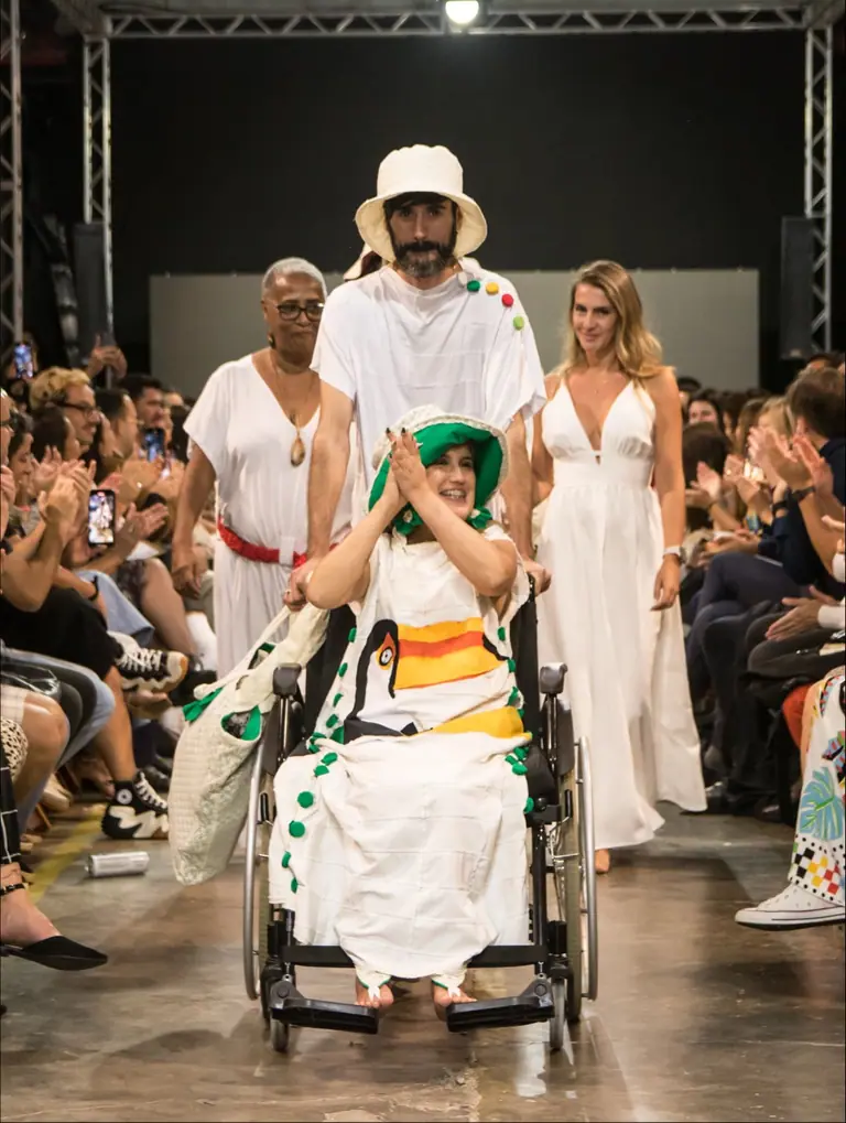 Modelo cadeirante desfila sorrindo na passarela do Friburgo Fashion Week