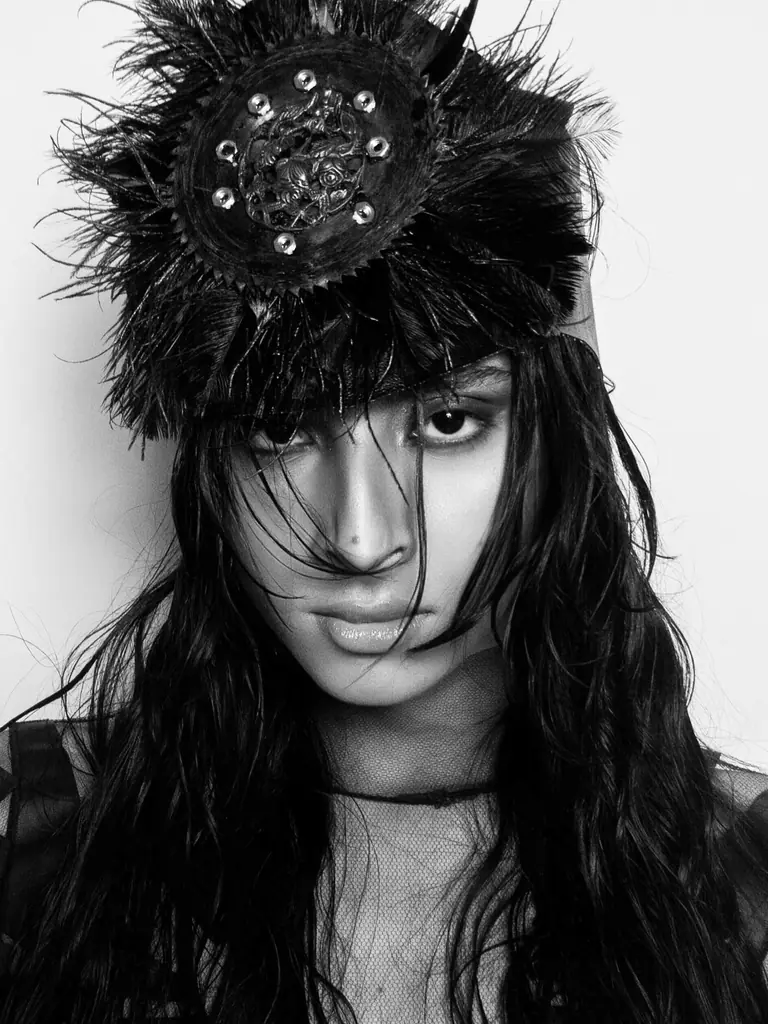 Retrato em preto e branco de modelo com cocar de plumas, editorial do BOOM! Novos Talentos