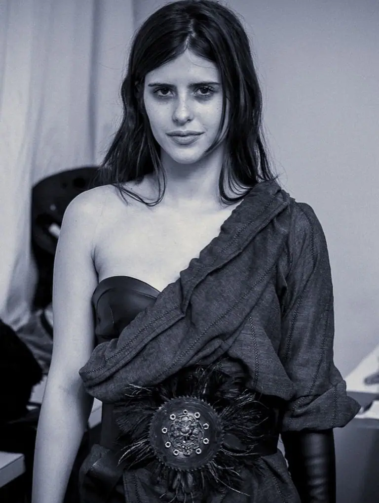 Prova de roupa nos bastidores: designer ajusta look em modelo, em preto e branco