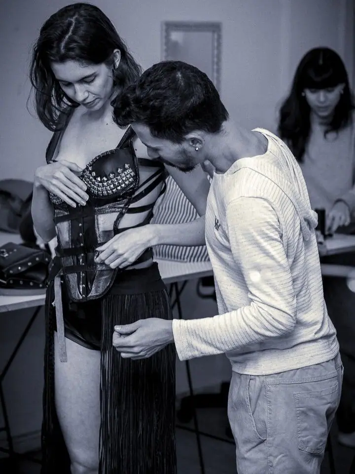 Designer ajusta corset em modelo durante a prova de roupa do BOOM!